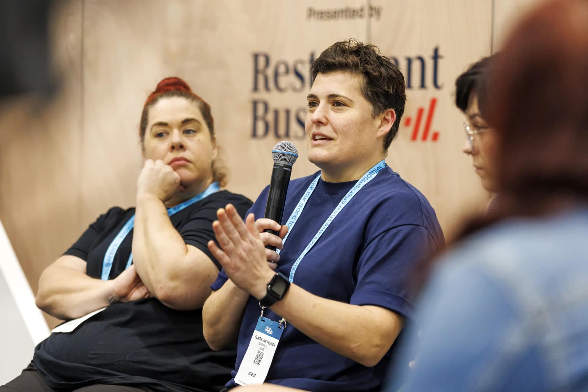A panellist speaking into a microphone during a stage discussion