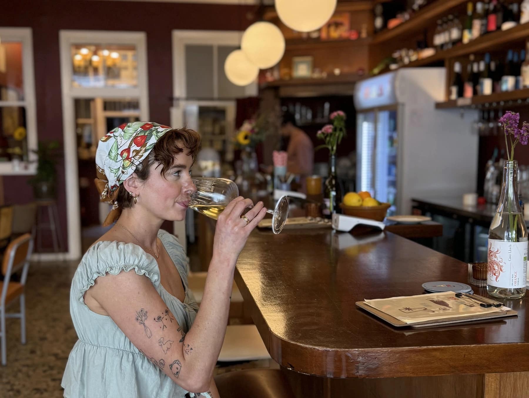 Louise Marks seated at her bar with a glass of wine