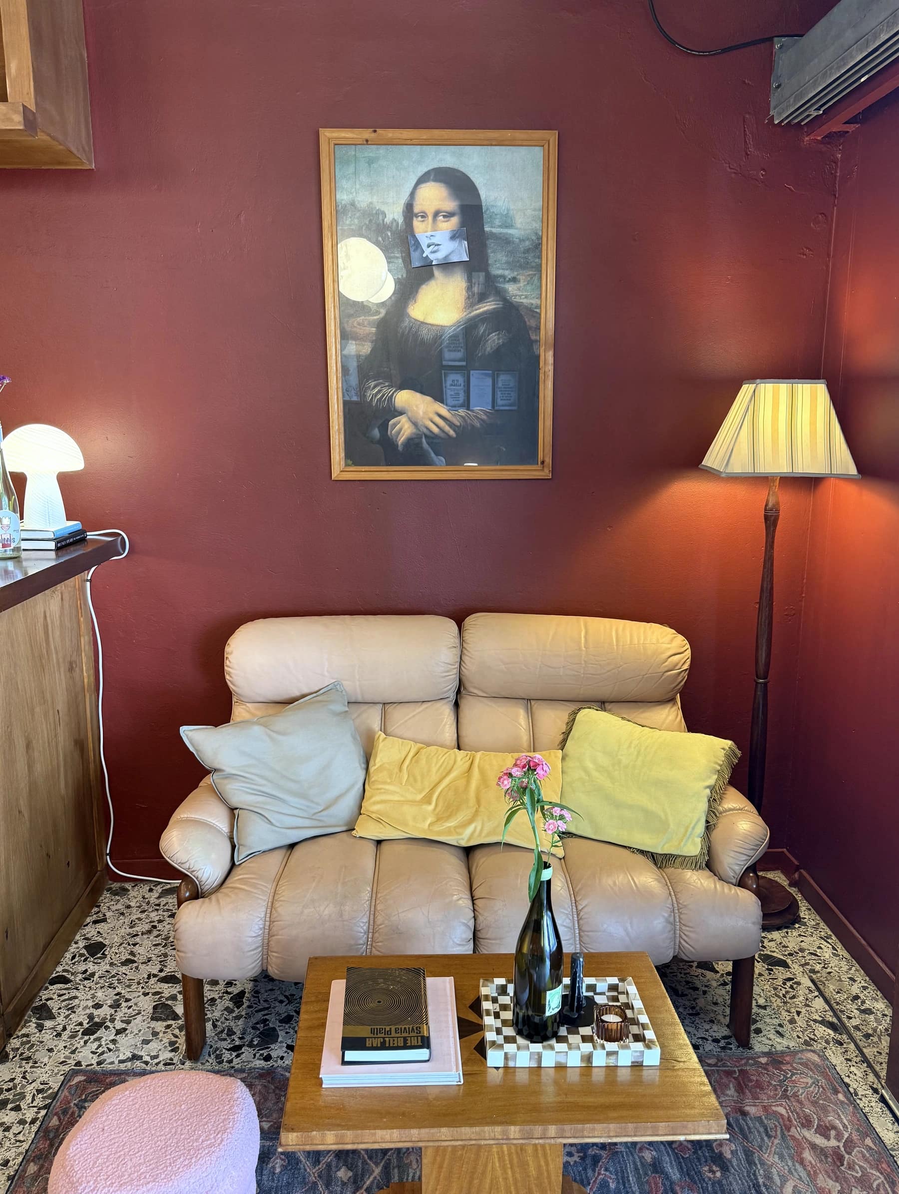 A secondhand armchair and artwork in a corner of Bar Lou Lou