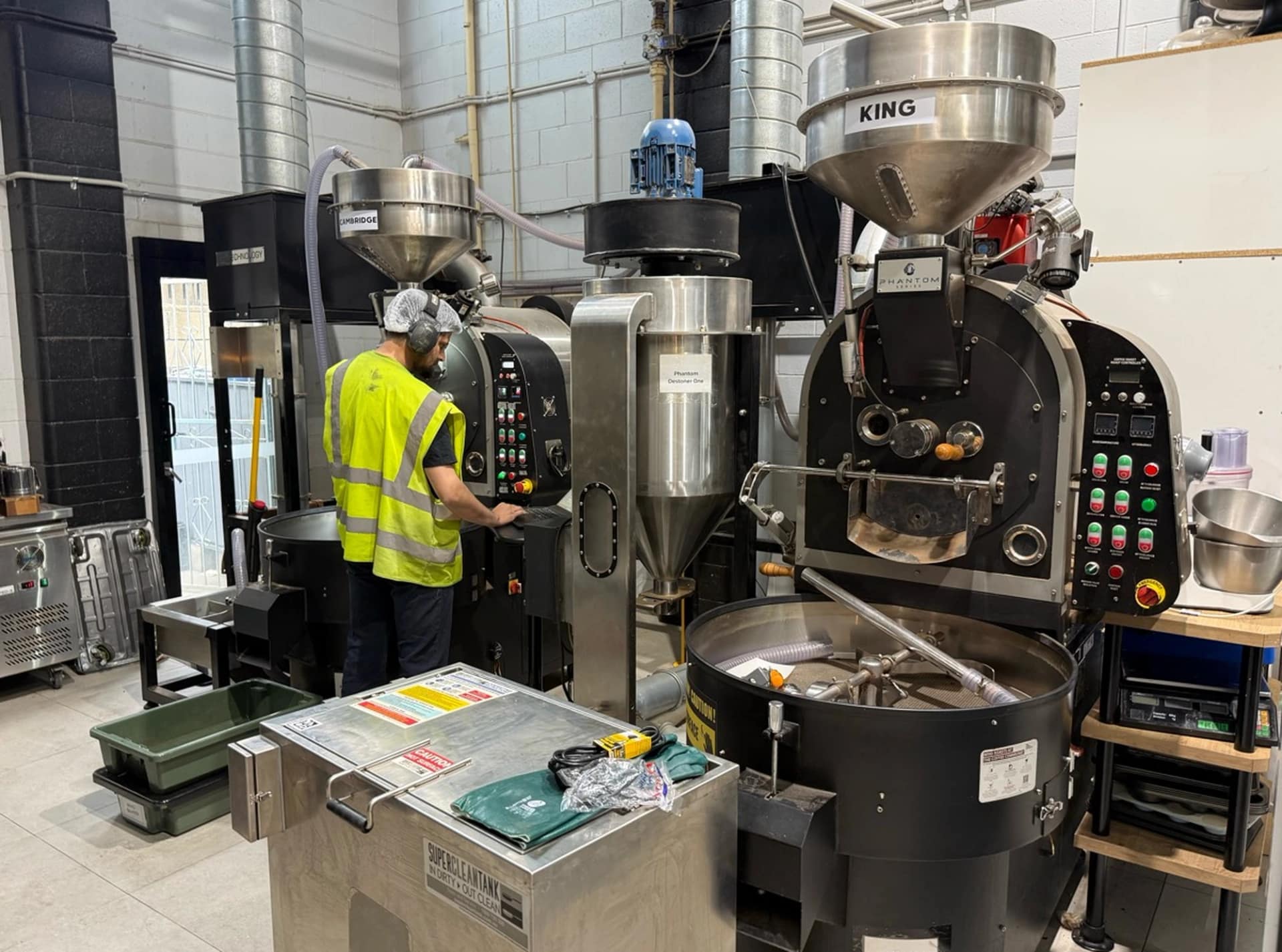 A staff member operating roasting equipment at The Coffee Commune