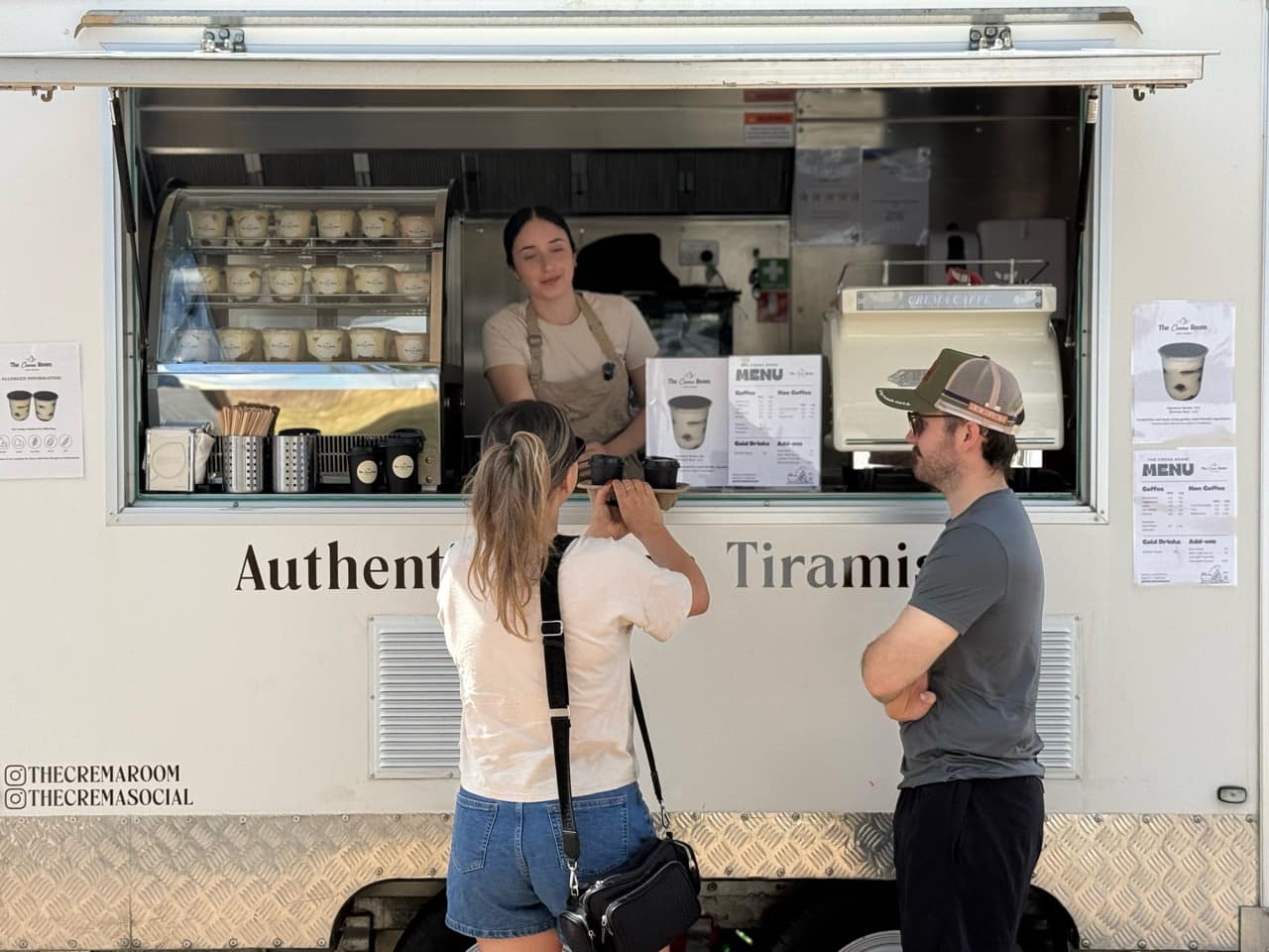 Customers collecting an order from Suzan at The Crema Room serving window