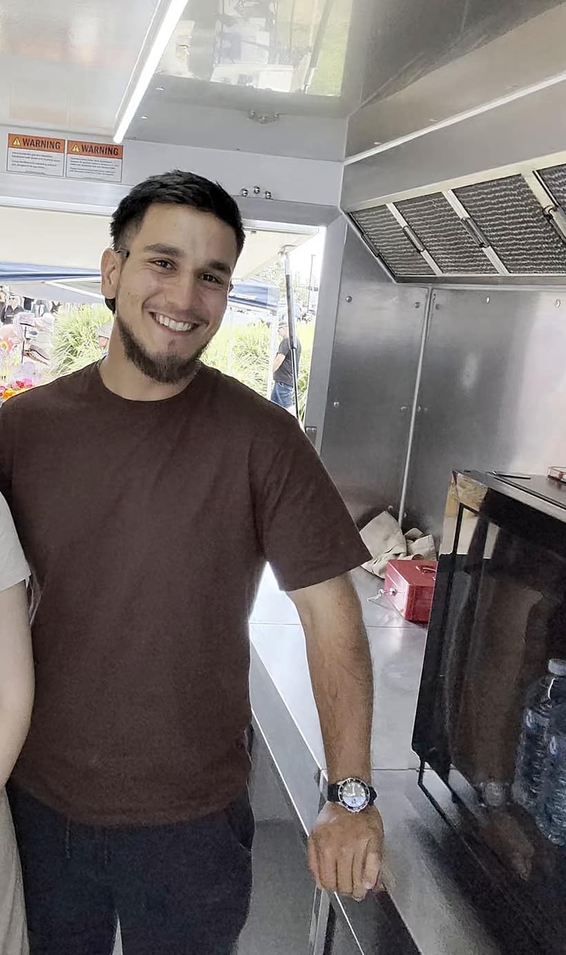 Hamza smiling inside The Crema Room trailer during the Brisbane Food Guide interview