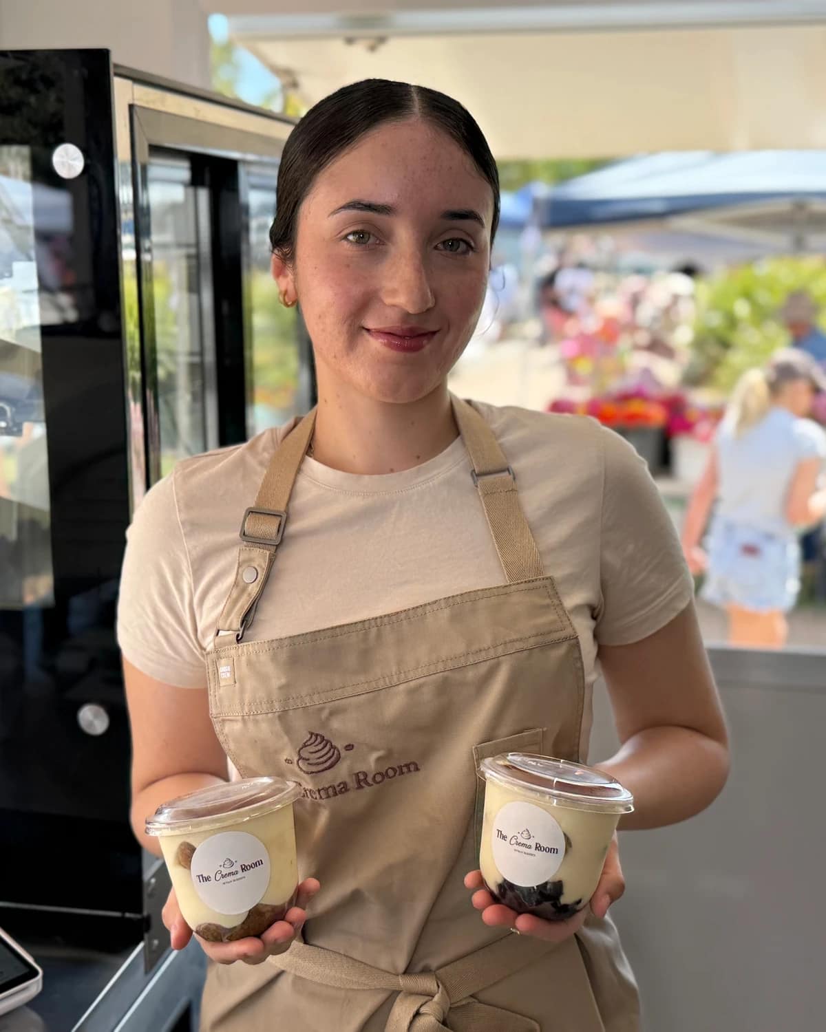 Suzan holding two tubs of tiramisu at The Crema Room