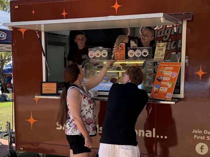 Sarah and Sam serving customers at the Fudging Delicious trailer window