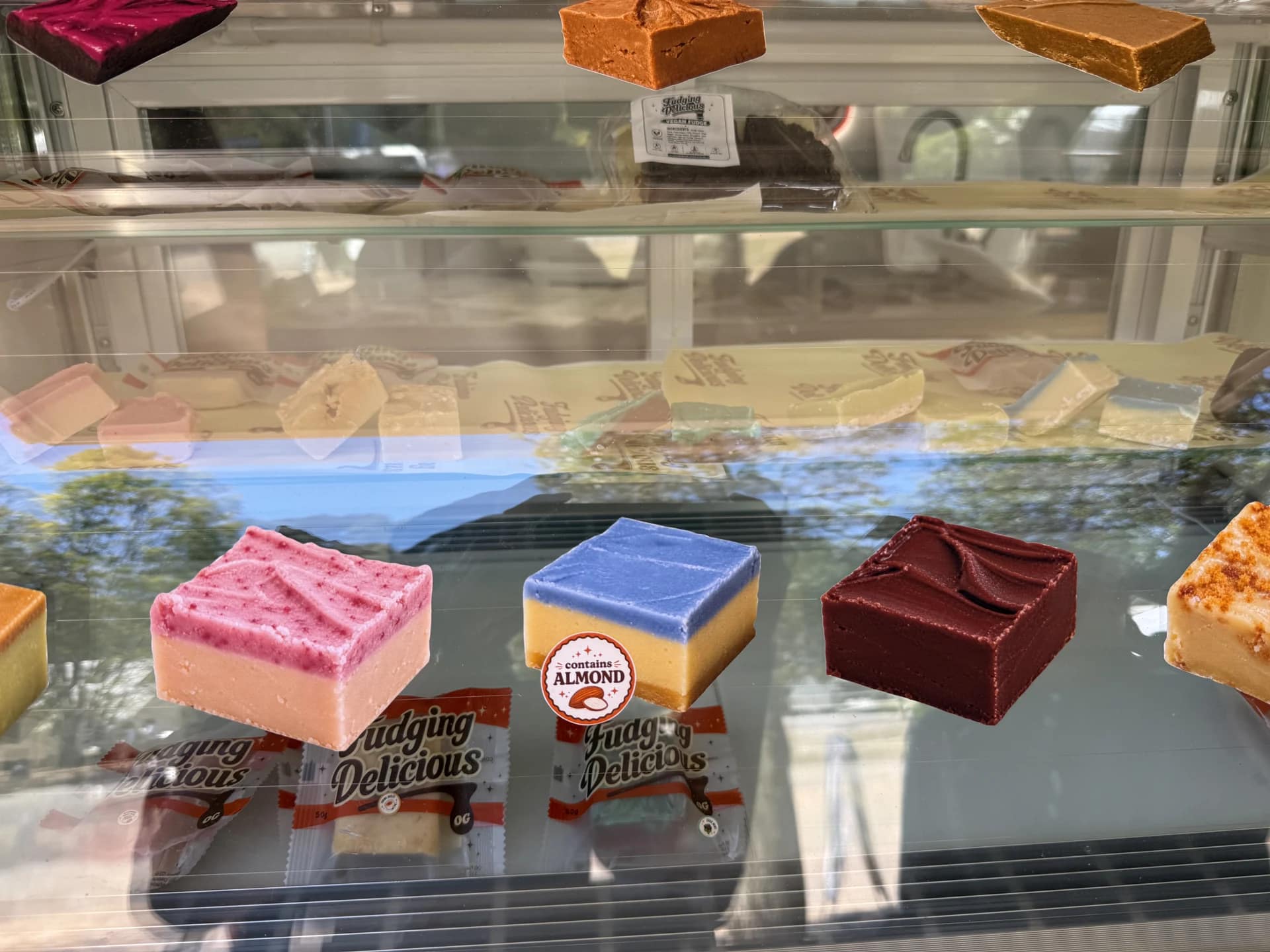 Colourful squares of fudge displayed above Fudging Delicious packets