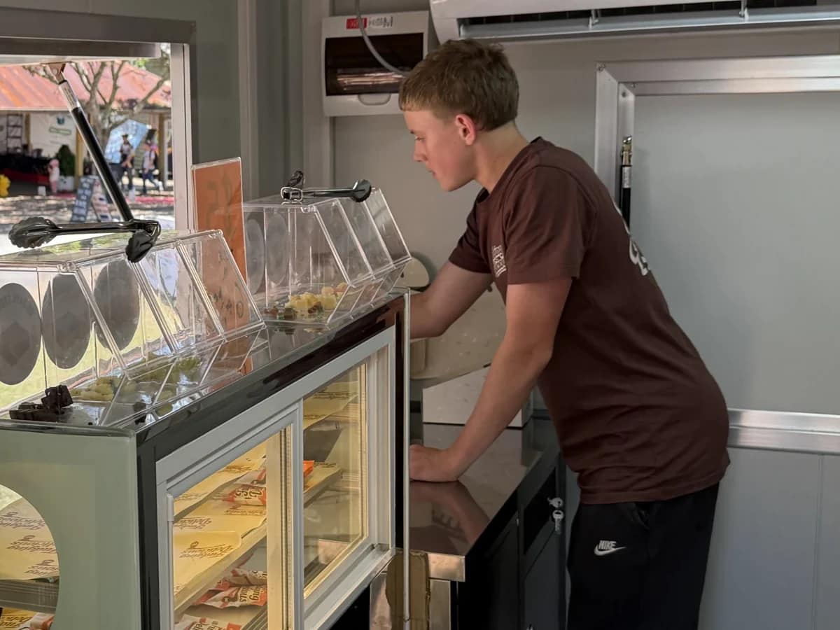 Sam leaning over the counter inside the fudge trailer
