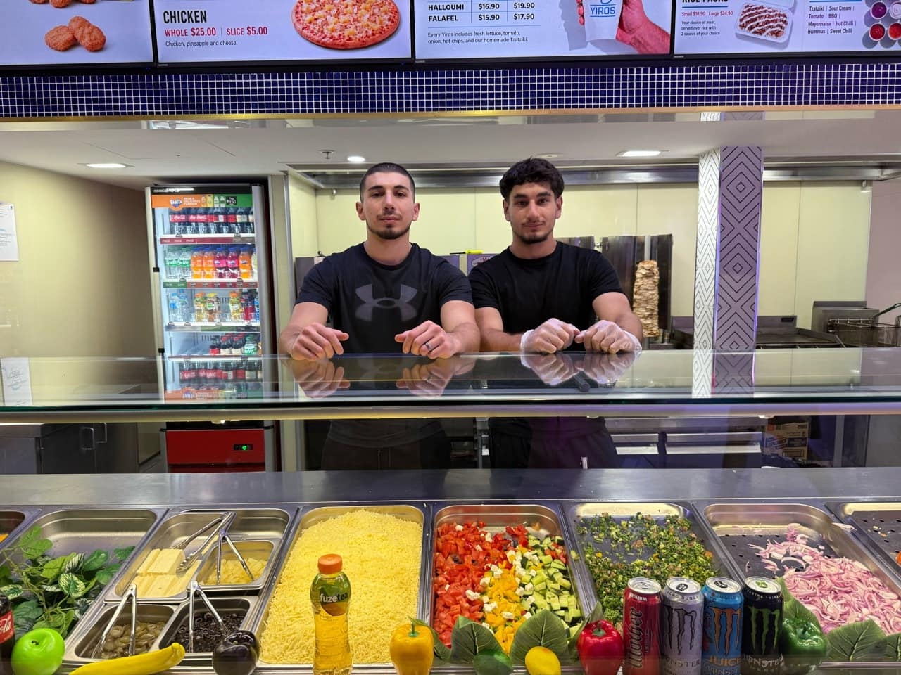 Muhammad Ali and his brother behind the Ozi Yiros counter.