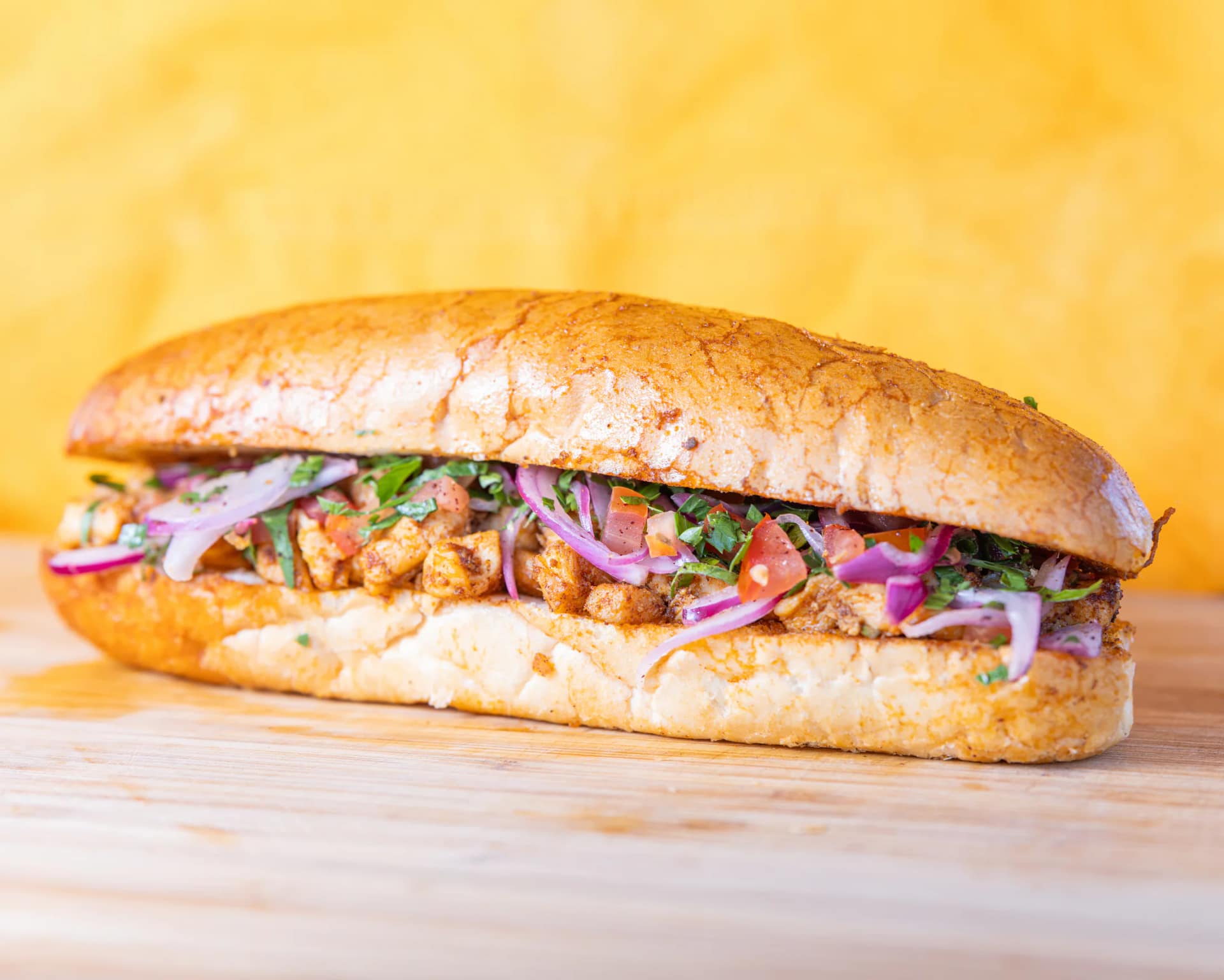 Chicken tantuni bread roll with tomato, red onion and parsley from Kuzine Turkish Street Food