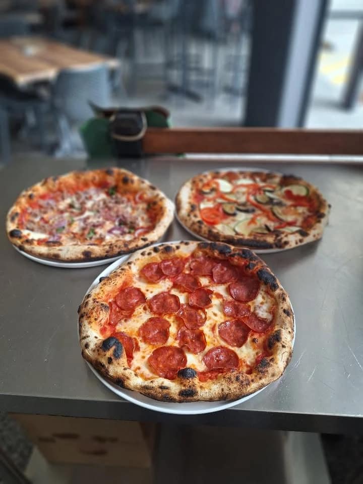 Three Solo Italiano pizzas on a stainless-steel counter