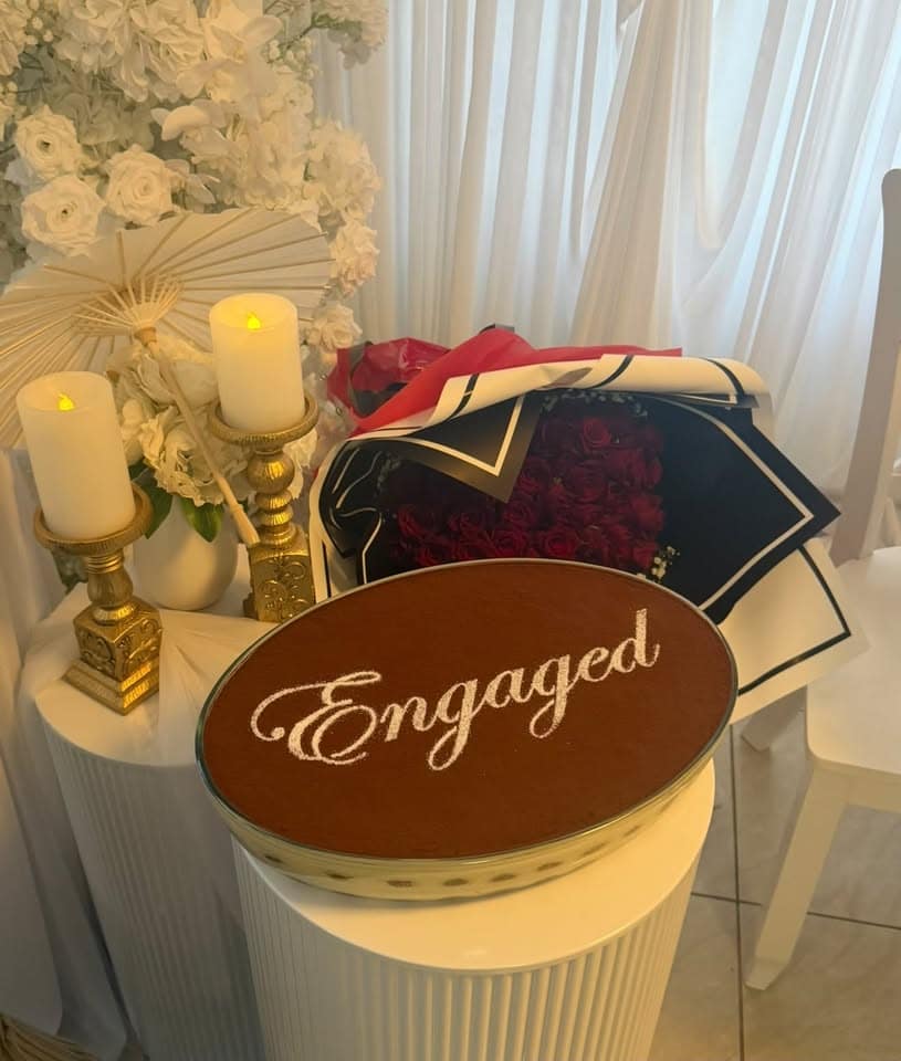 An oval tiramisu dusted with "Engaged" at an engagement party