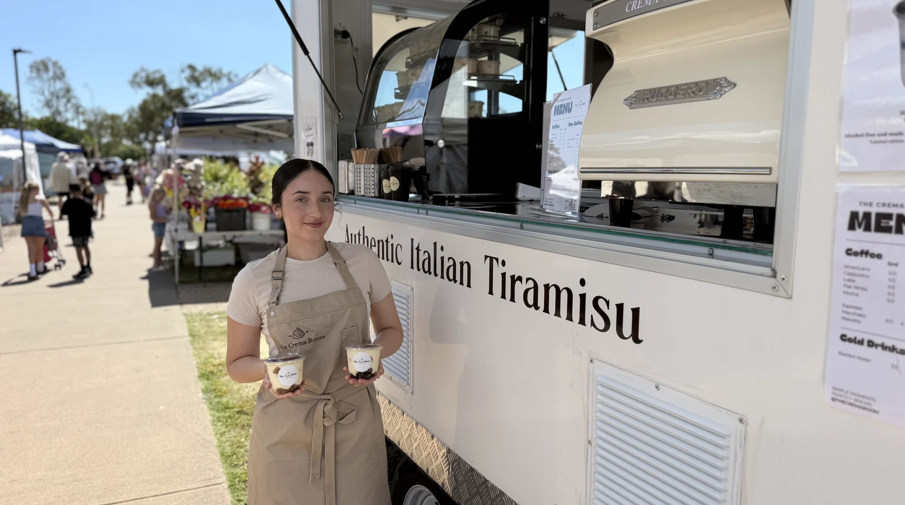 Suzan holding two tiramisu cups outside The Crema Room trailer