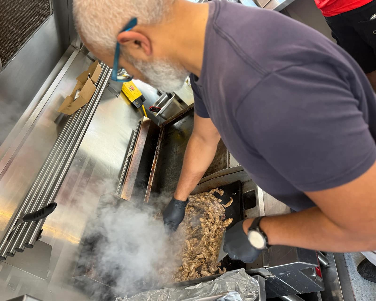 Chicken shawerma on the grill during preparation.