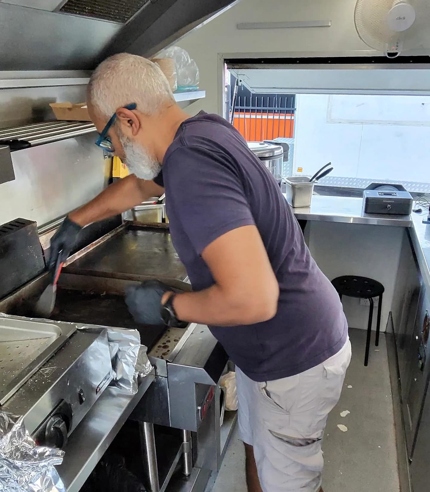 Working the flat-top grill in the confined kitchen.