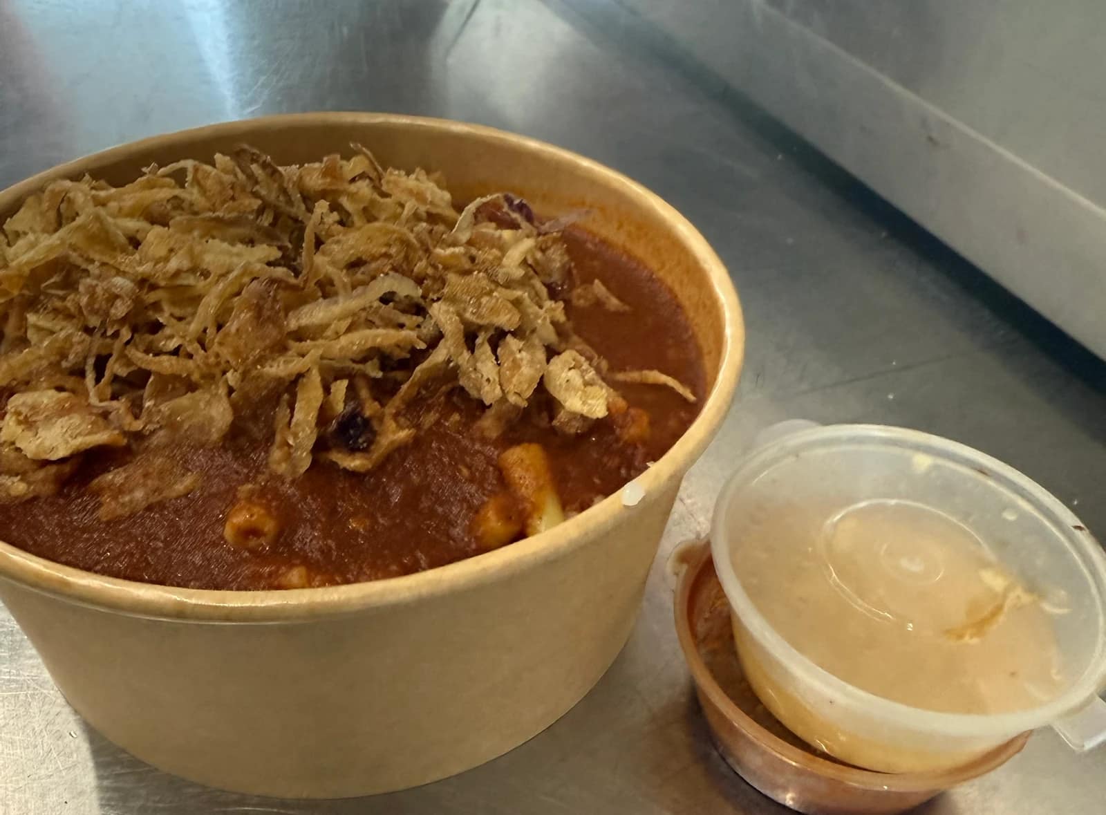 Koshari with fried onions, and sauces on the side.
