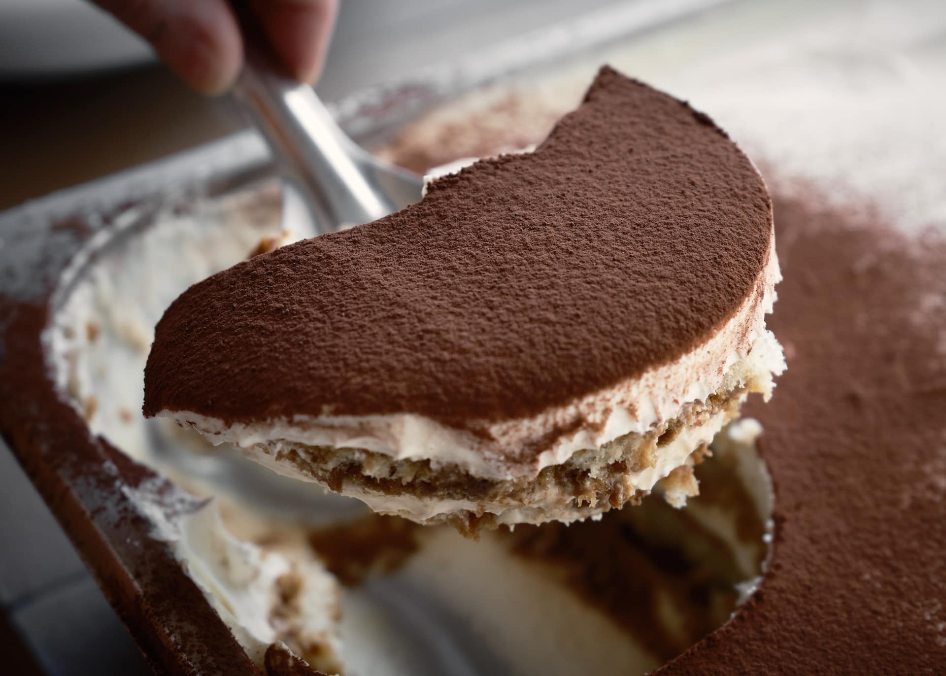 A serving of tiramisu lifted from a tray at Biànca