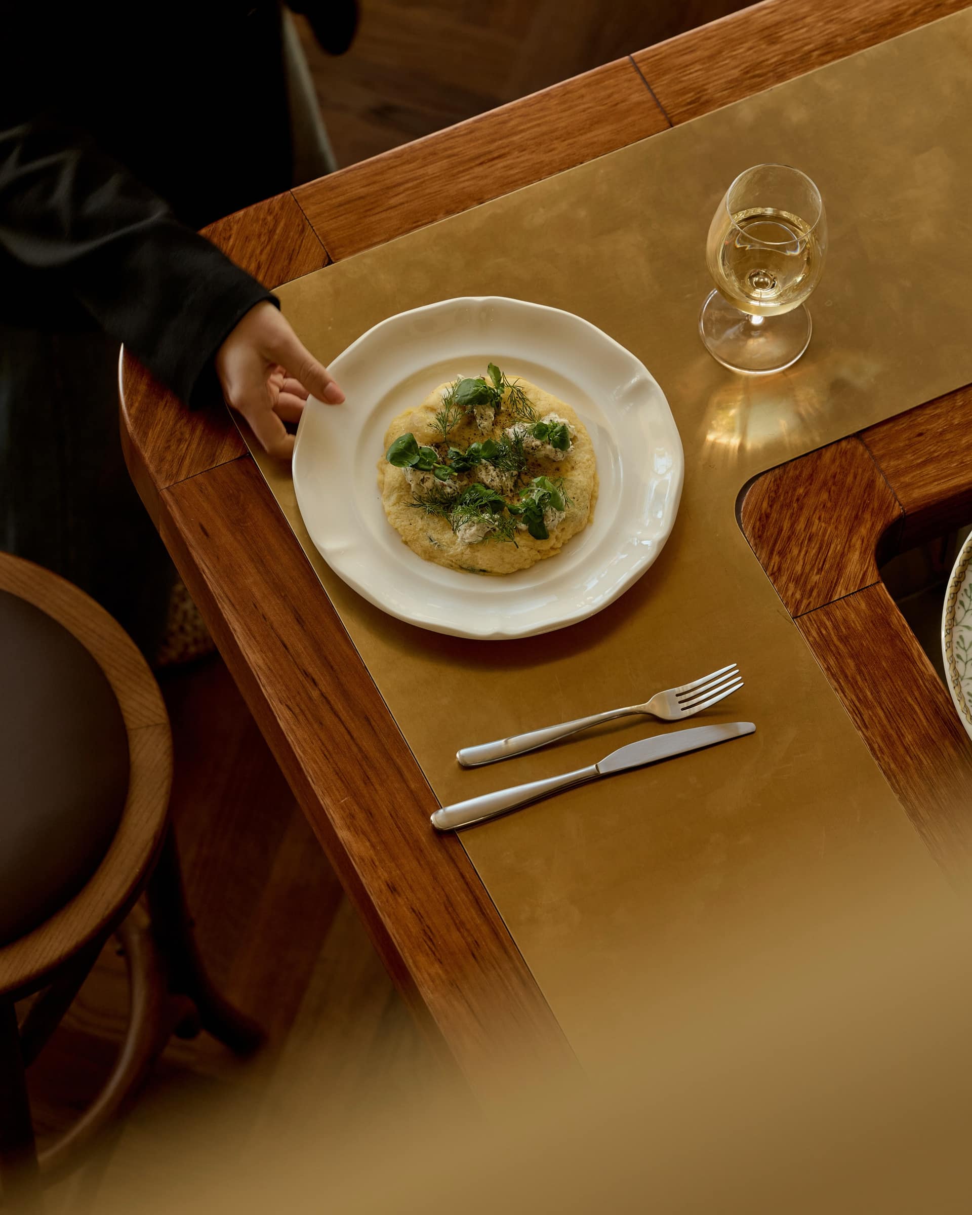 Crab frittata with herbs on a white plate at Bistro Tino, being served at the timber bar