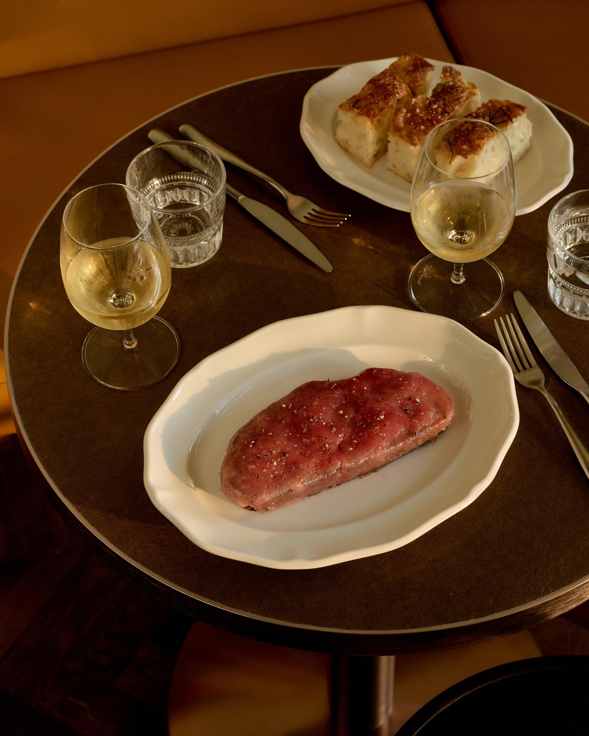 Tuna on sourdough at Bistro Tino with bread and wine glasses across a shared table