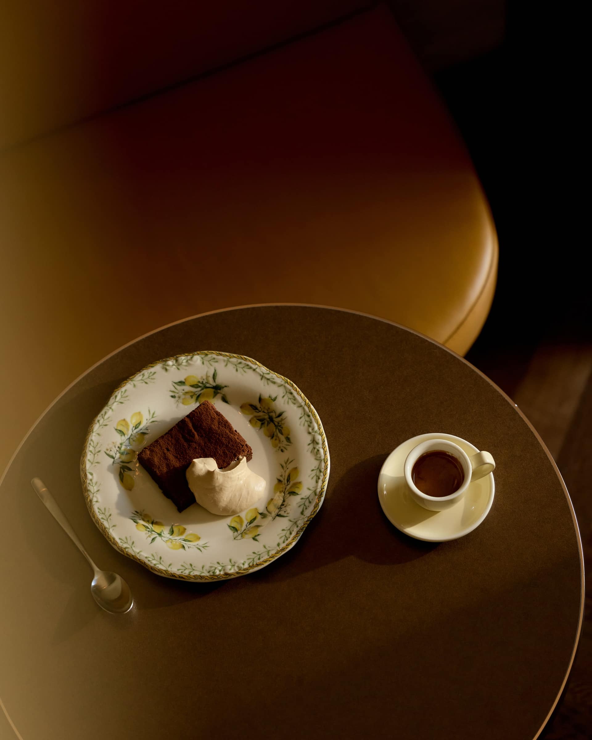 A slice of cake on floral china beside an espresso at Bistro Tino