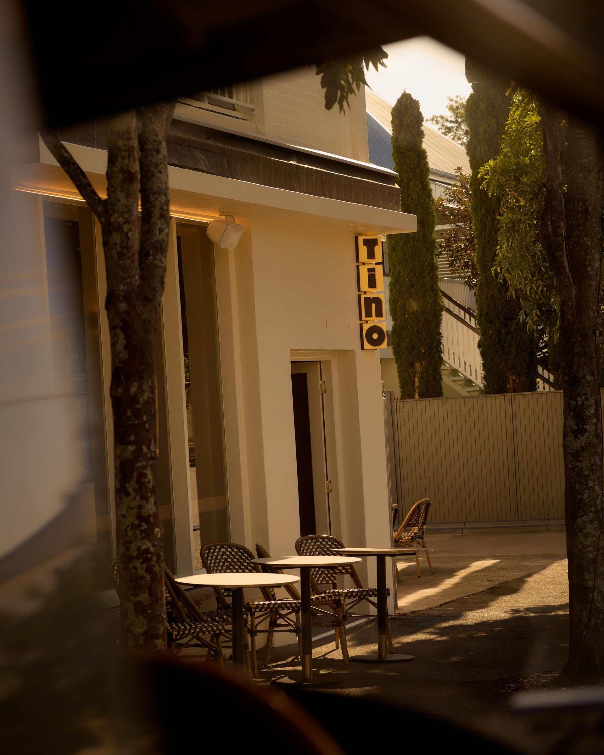 The yellow Tino sign and footpath tables outside Bistro Tino on Arthur Street