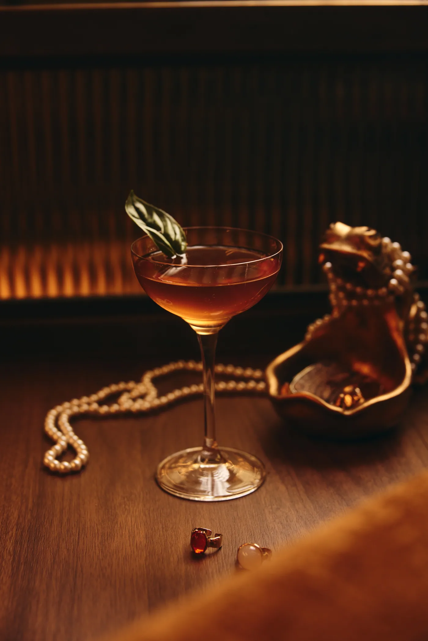 A cocktail in a coupe glass inside Penelope's softly lit lounge