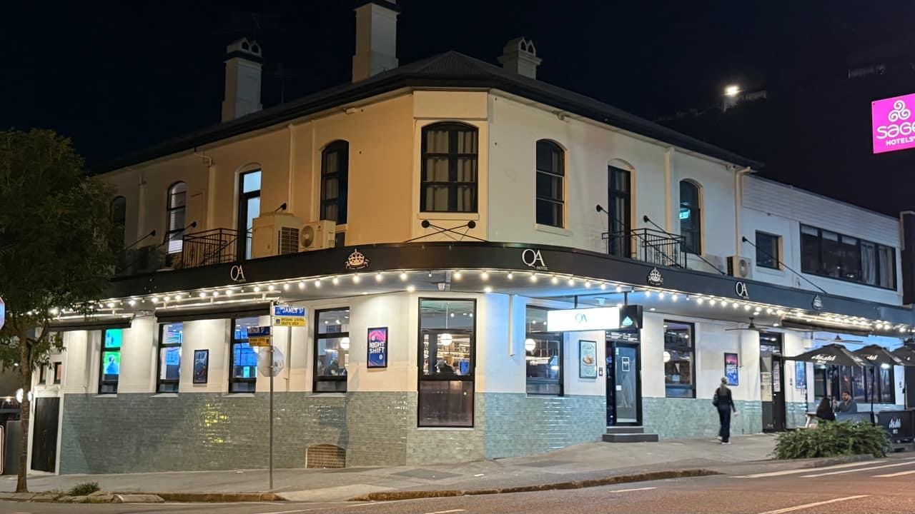 QA Hotel on the corner of James and Arthur streets, with its lights on at night